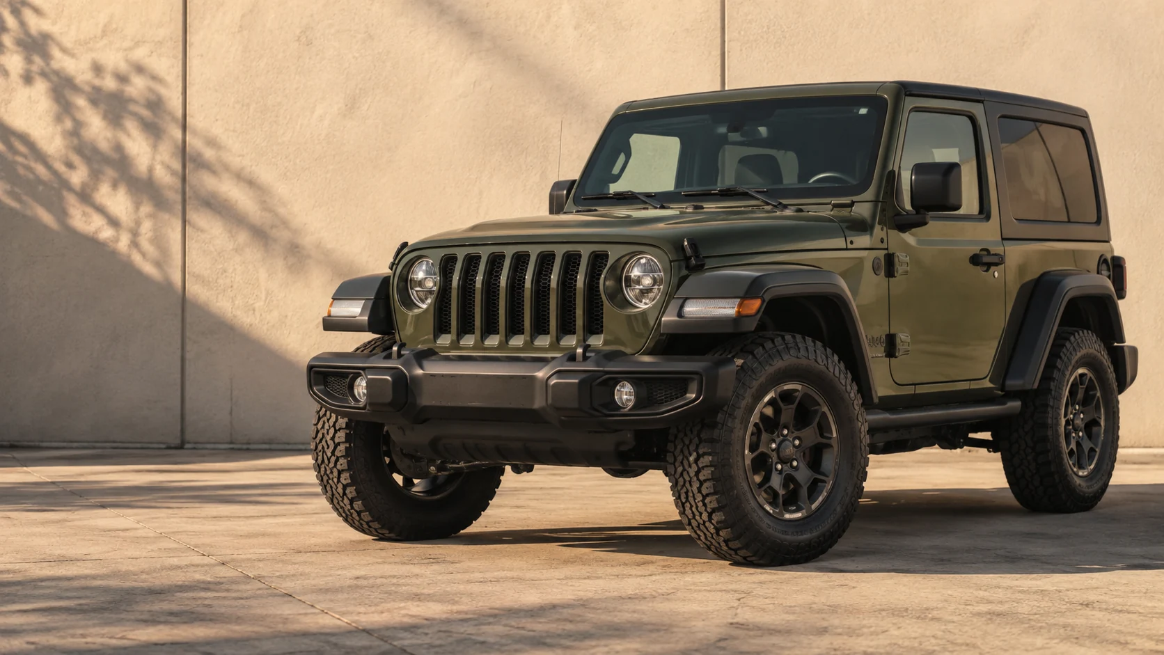 Illustrative olive Jeep parked against a sunlit workshop-style wall